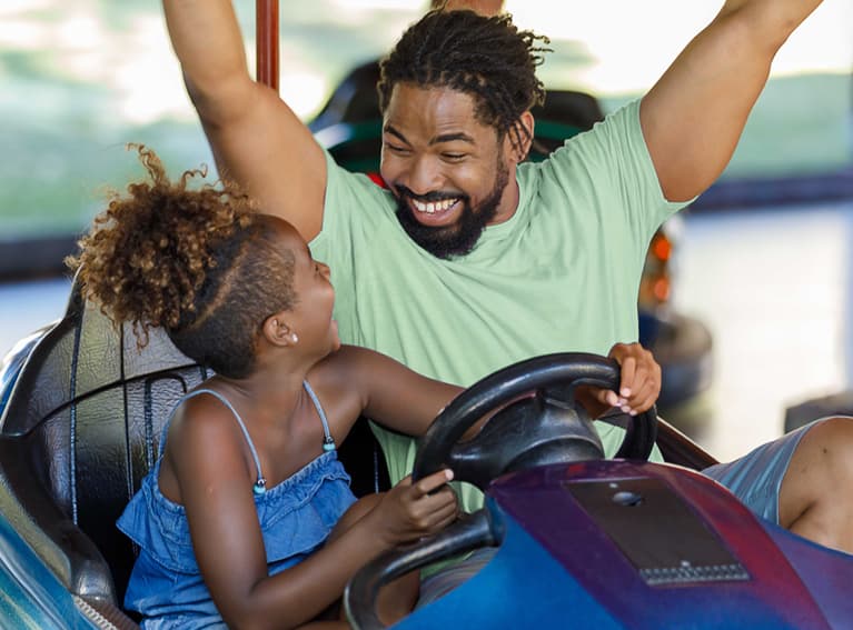 Dad and daughter in bumper car