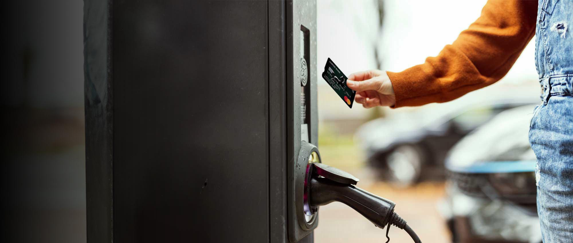 Image of a person holding a bank card to pay for Fuel