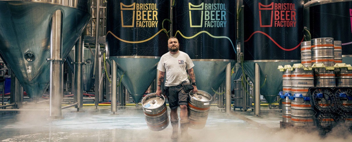 A man carrying beer barrels