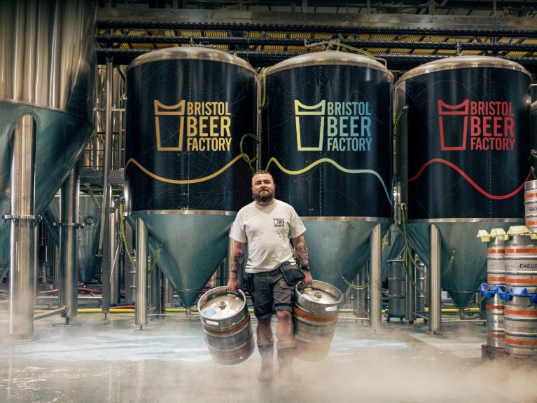 A man carrying beer barrels