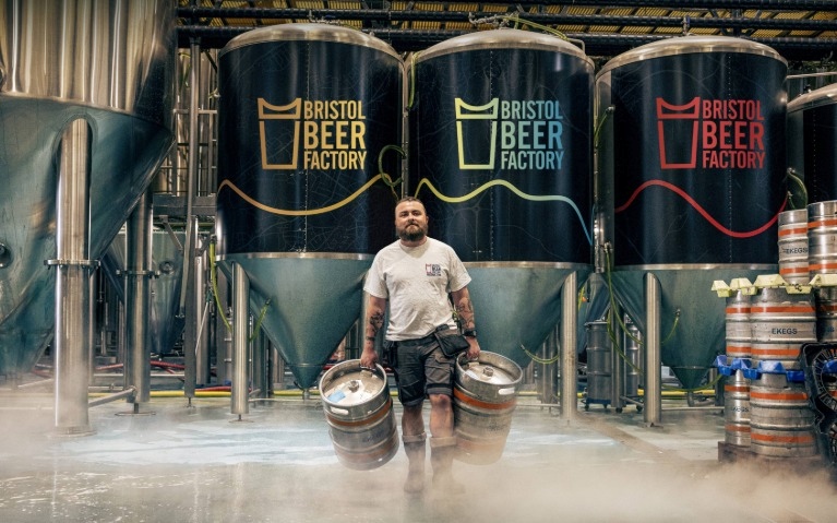A man carrying beer barrels