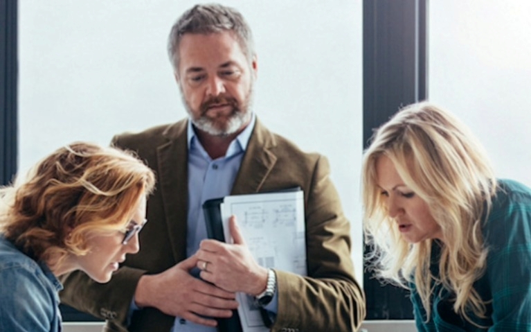 A group of people looking over plans