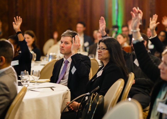Audience raising hands at event