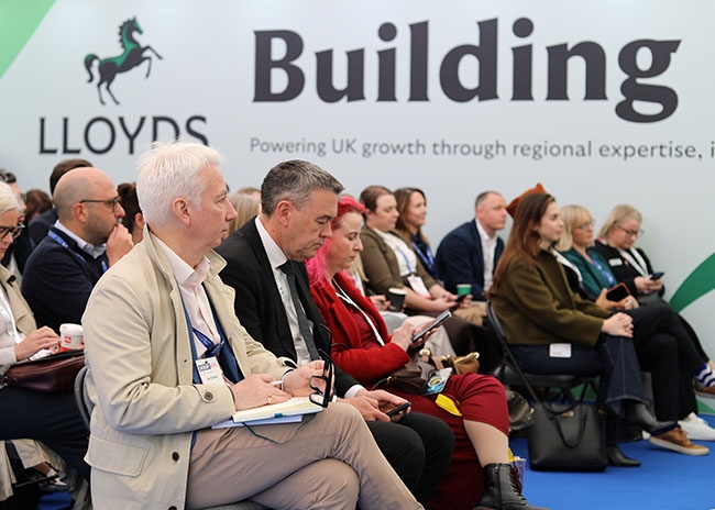 Audience members attending a Lloyds panel session at UKREiiF 2026 inside the Building Futures pavilion.