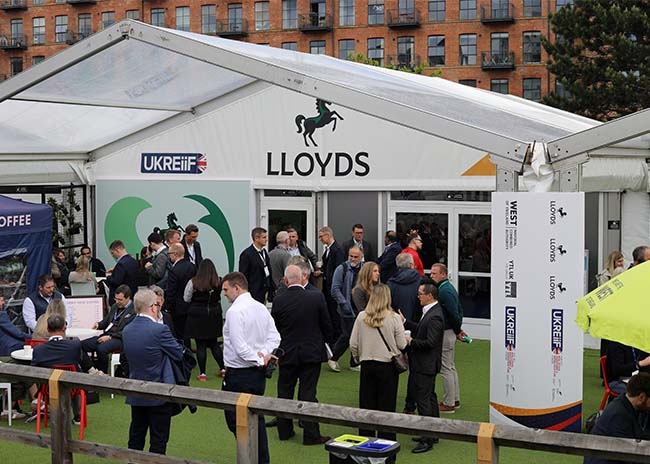 Exterior view of the Lloyds Building Futures pavilion with delegates gathering and networking at UKREiiF 2026.