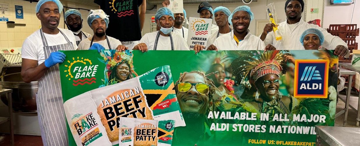 Flake bake team holding Aldi promotional banner