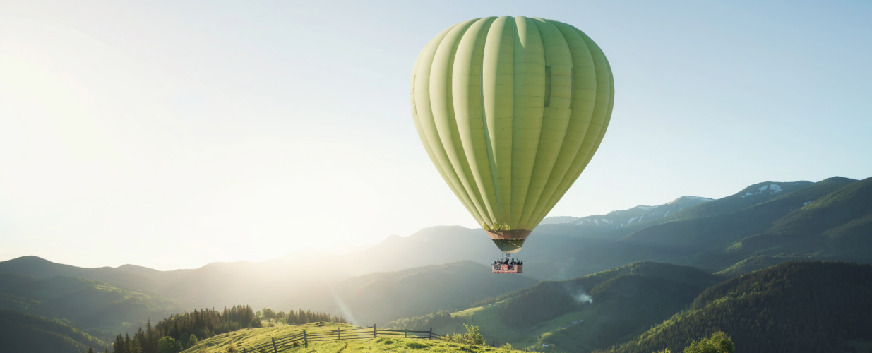 Hot air balloon with sun in horizon