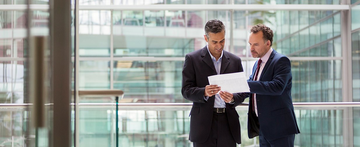 Two  business men discussing document in hallway