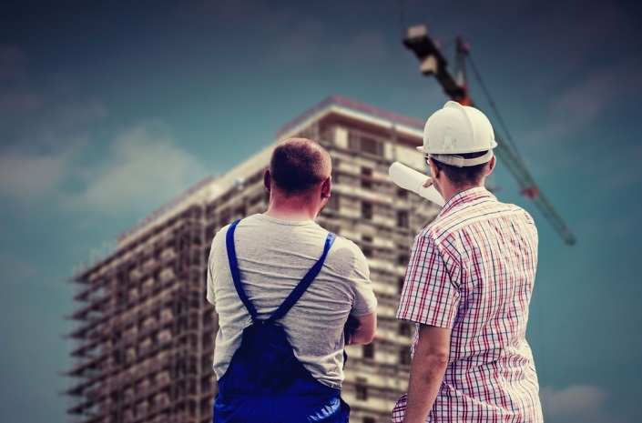 Two workers surveying an office block
