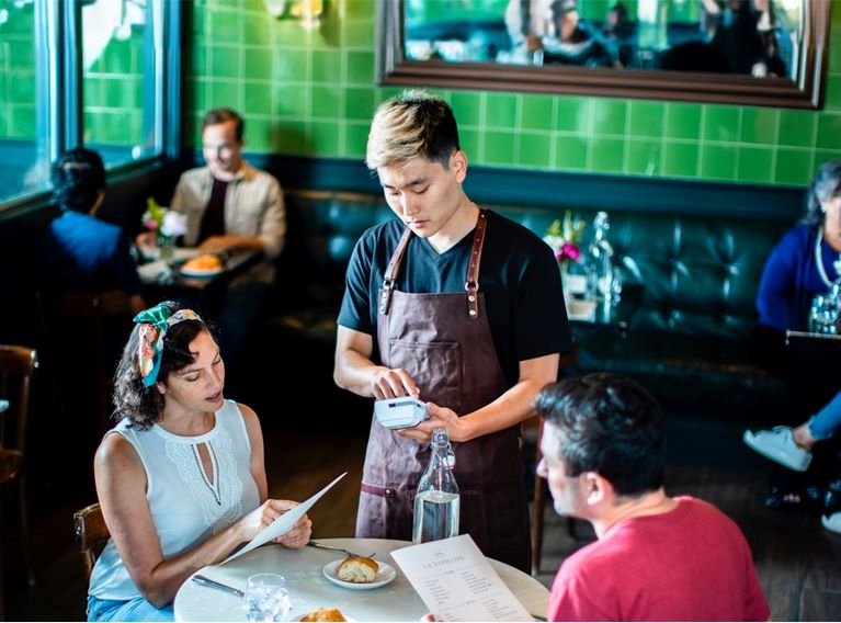 Waiter taking a payment using a Cardnet card machine