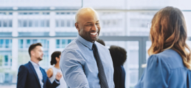 A group of Relationship Managers and clients shaking hands at an event