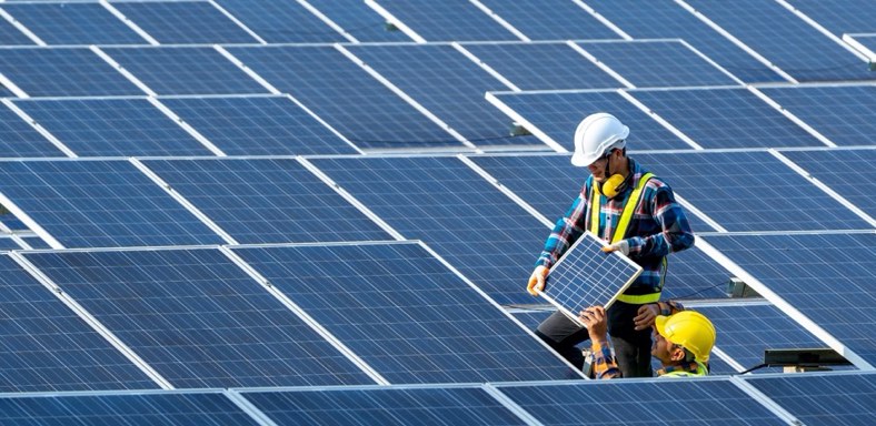 Installer fitting solar panels on roof