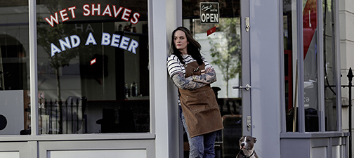 a woman stood outside a barbers shop