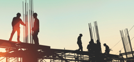 Construction workers conversing on a building site.