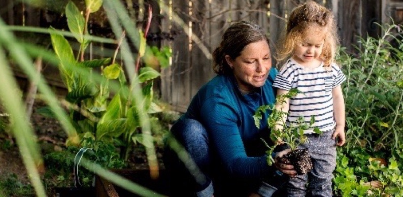 Woman planting plants with child