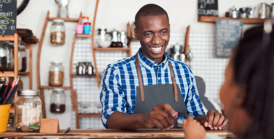 Café owner taking payment from a customer