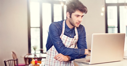 Barista sending a payment link to a customer using a laptop.