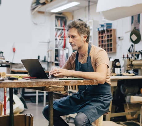 Person in apron using a laptop
