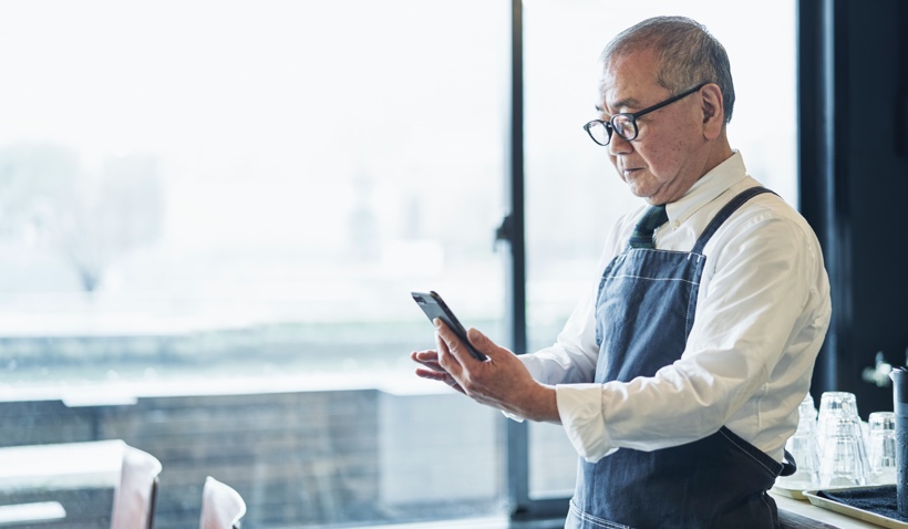 Man in apron on laptop