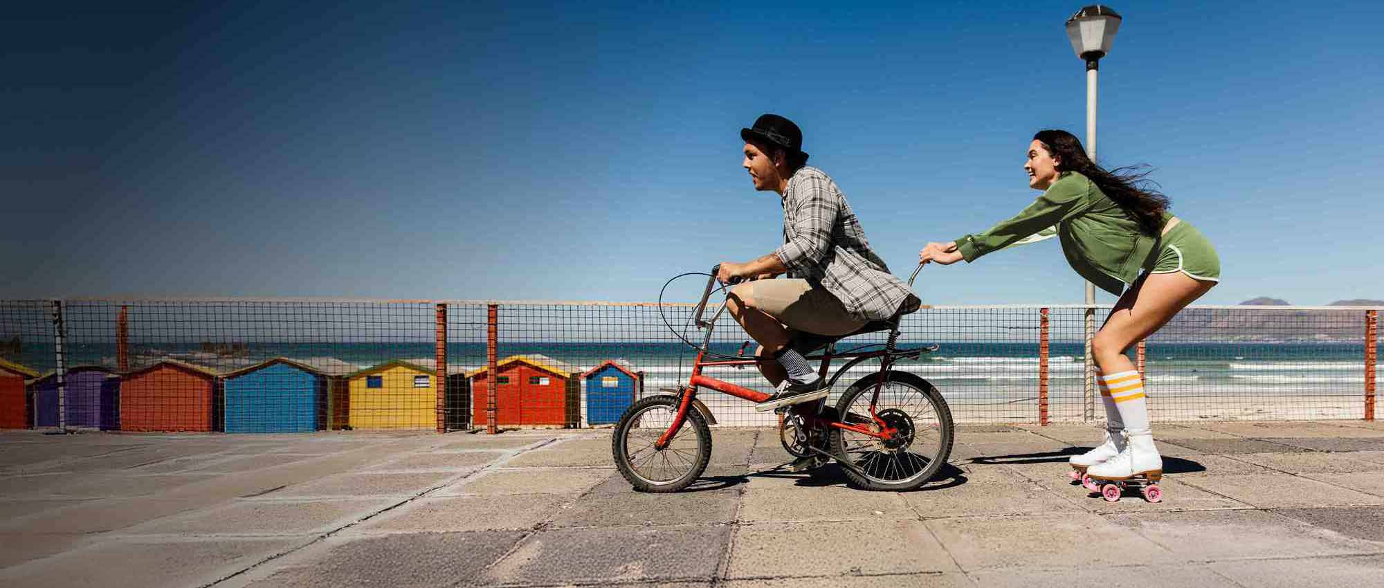 Two people on a bike and roller skating