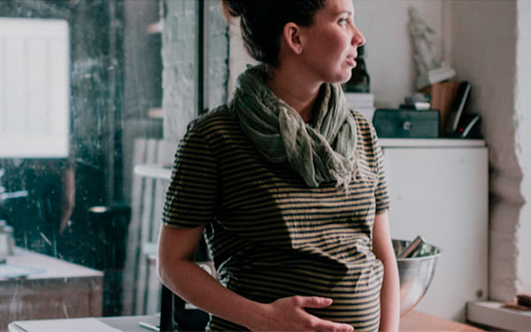 Pregnant person holding her bump