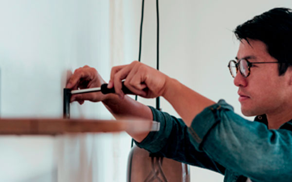 Man fixing a shelf to wall