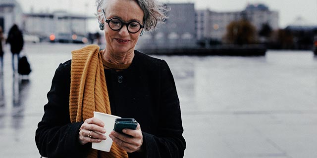 Person on a phone holding a drink going for a walk