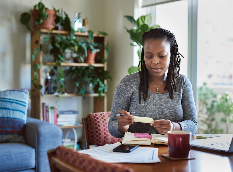 A woman sitting at a table while checking some notes