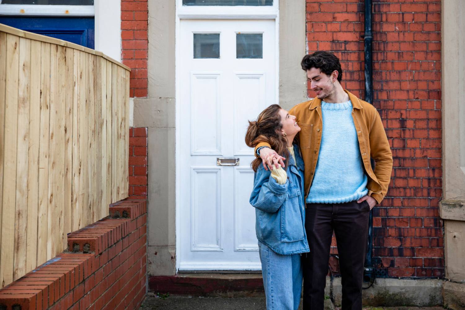 Two people outside a house.