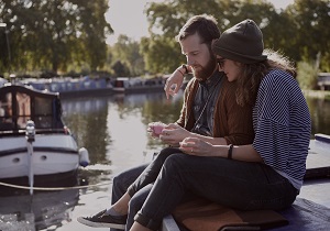 A man and a woman sitting by the riverside.