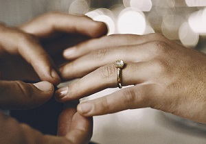 A ring on the fourth finger on the left hand.