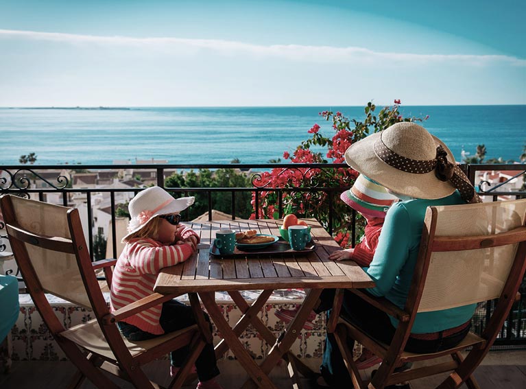 Mum and daughter wearing hats over looking the sea image