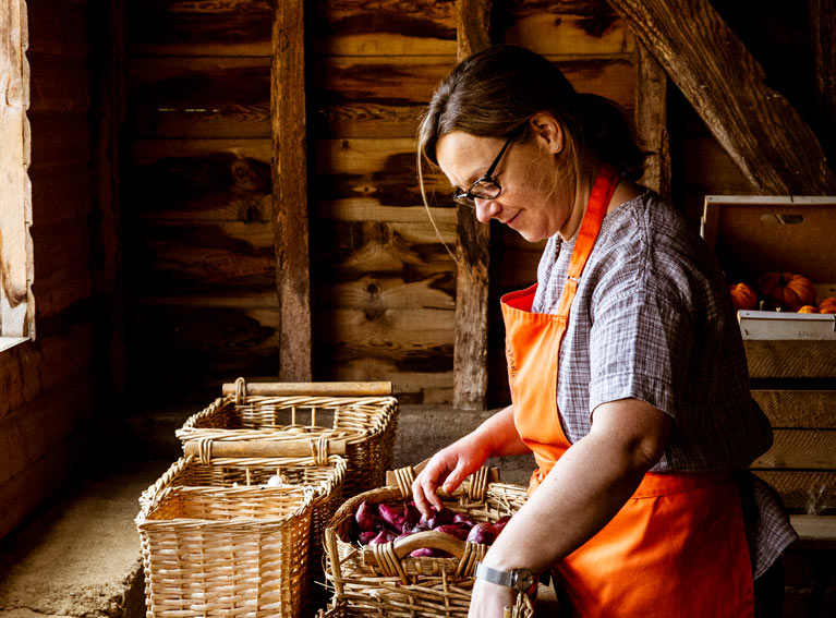 Woman tending baskets in a shed.