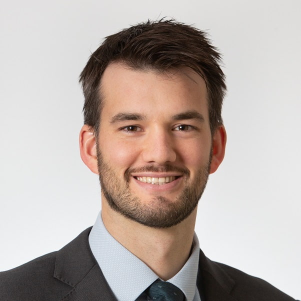 Head shot of Stephen Ogborn. Brunette with short hair - wearing black jacket and dark blue tie.