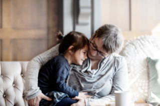 Woman hugging child on sofa