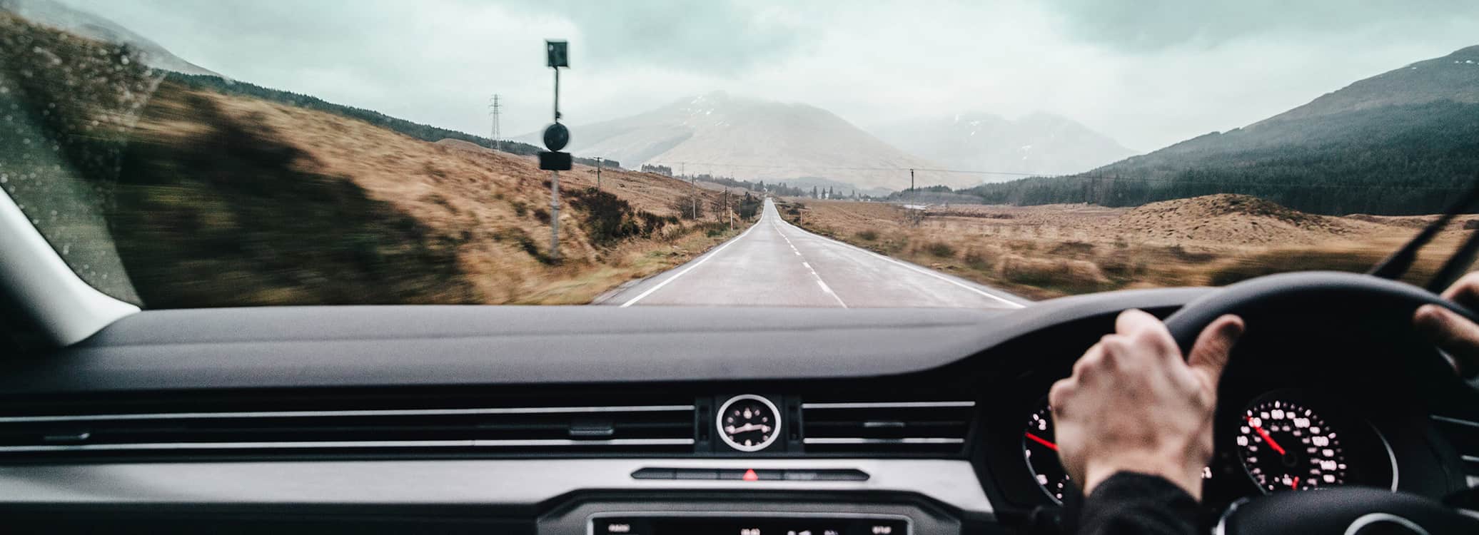 Man driving down a long straight road