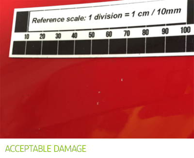 Acceptable damage - red car with very small areas of chipped paint.