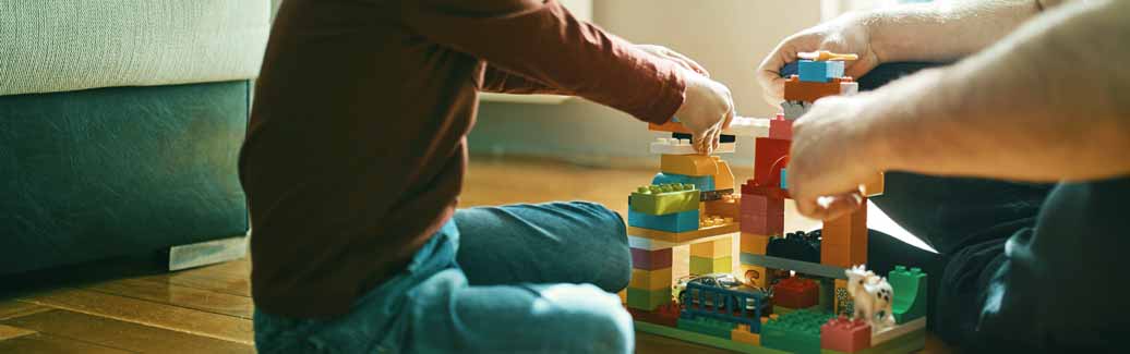 Parents playing building blocks with a child.