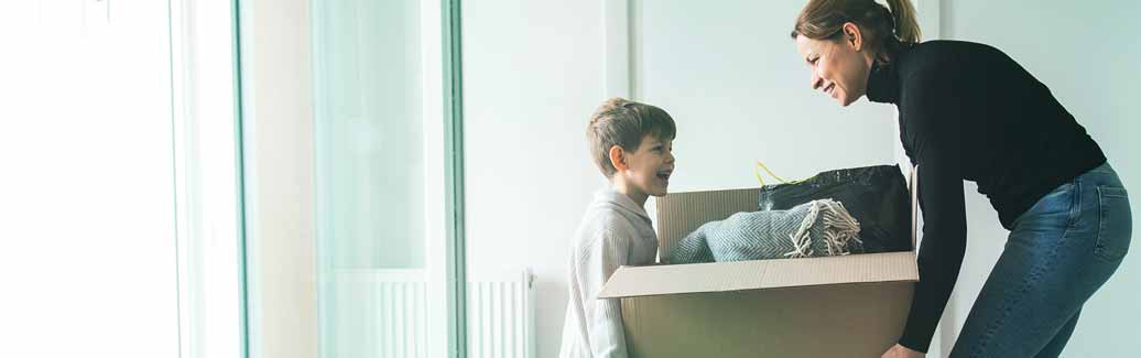Mother and young child packing belongings into boxes