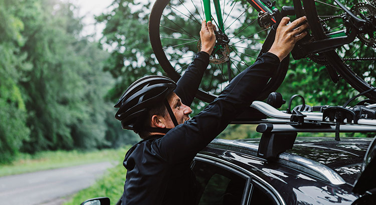 Man putting a bike on his cars bike rack