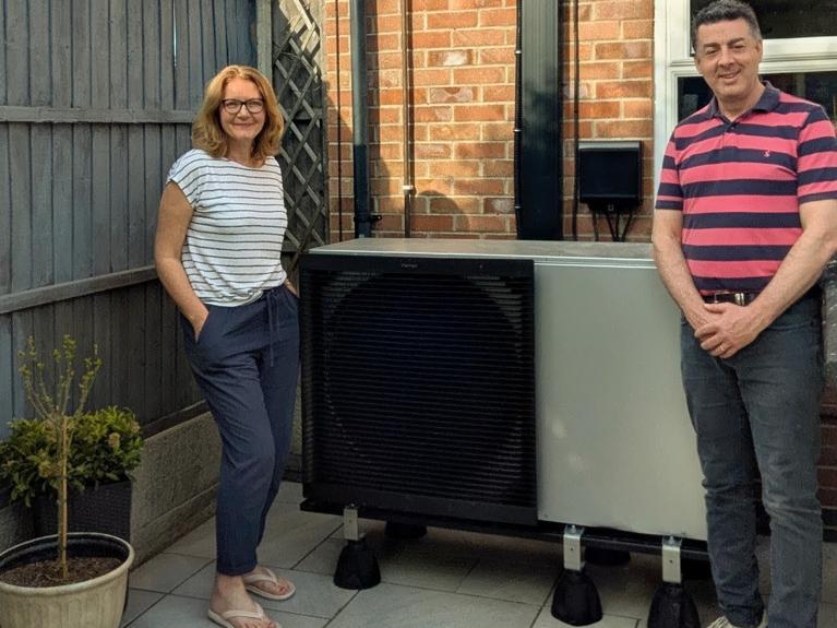 Our customers smiling next to their heat pump.
