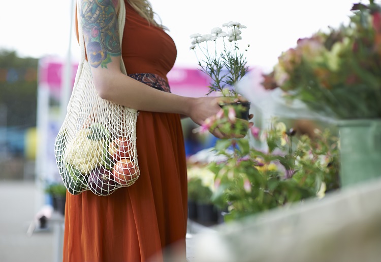 A lady picking out flowers at a flower market.