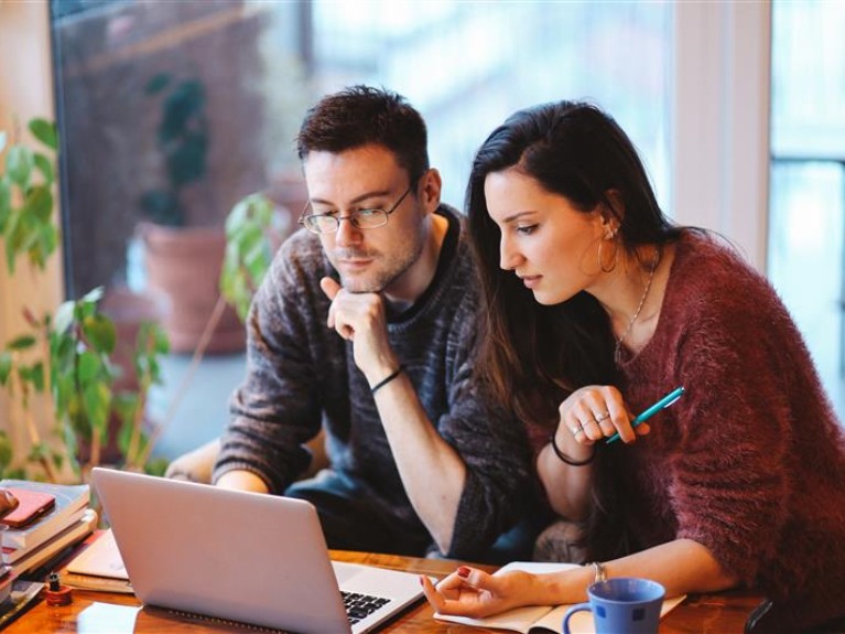 Man and woman looking at laptop.