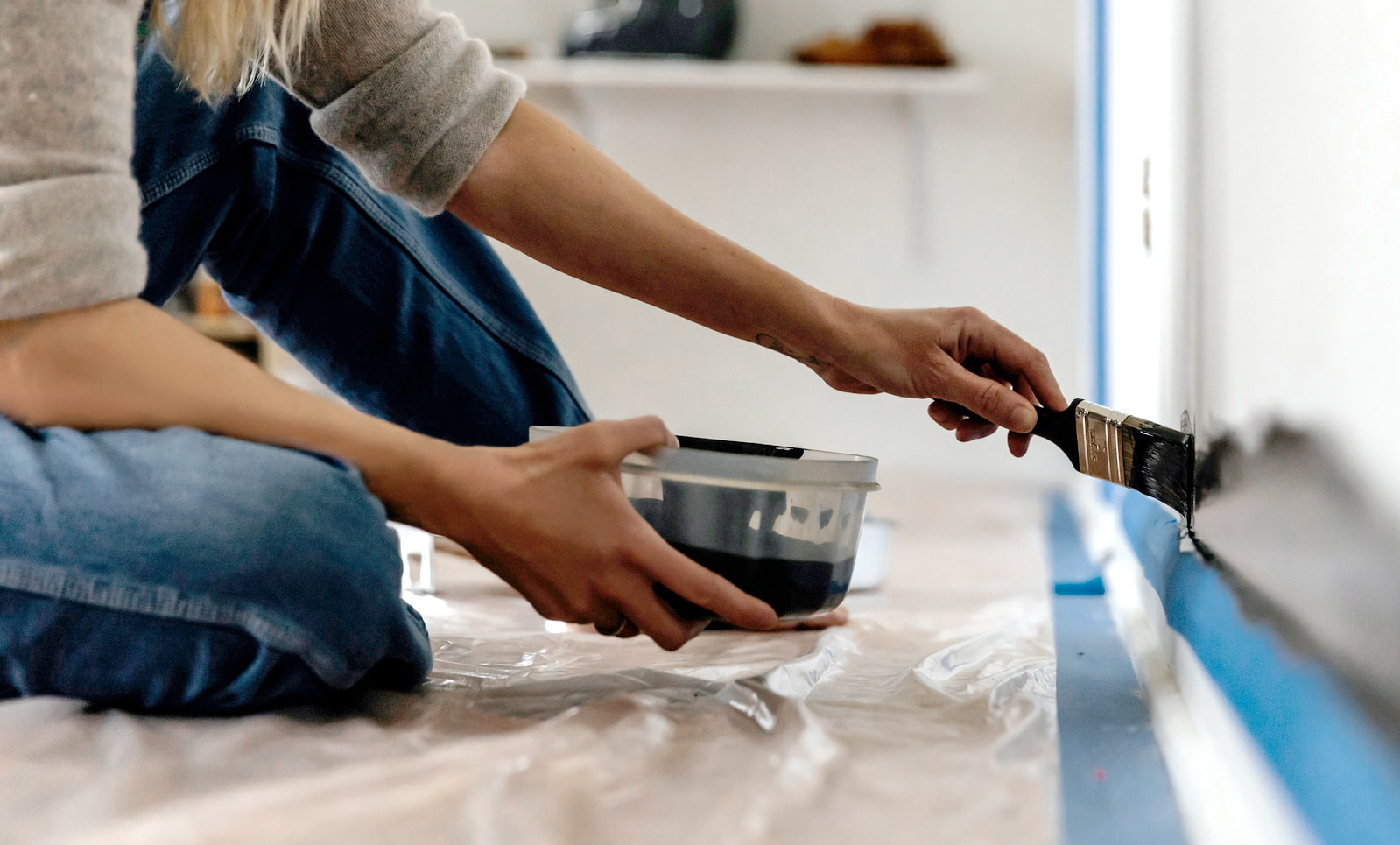 Someone painting a wall in their home