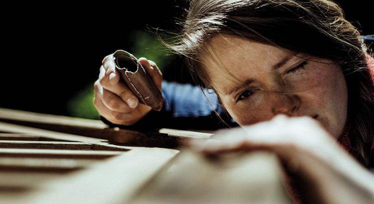 Woman sanding down some wood