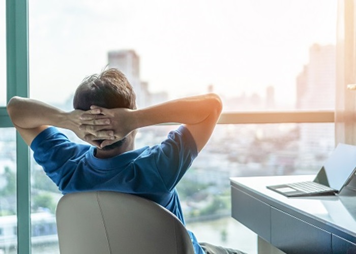 An image of a man looking out of his office window.