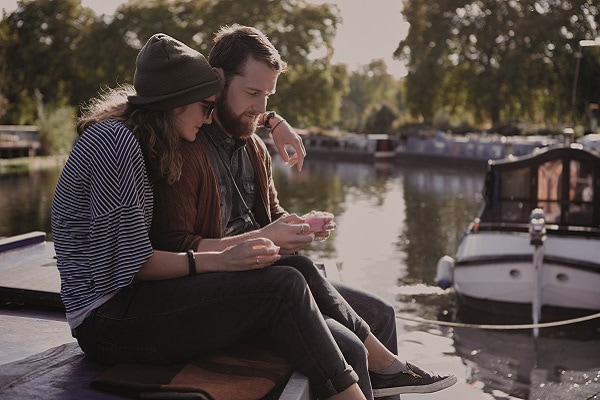 Young couple siding on canal boat