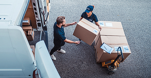 woman and man loading boxes into a van
